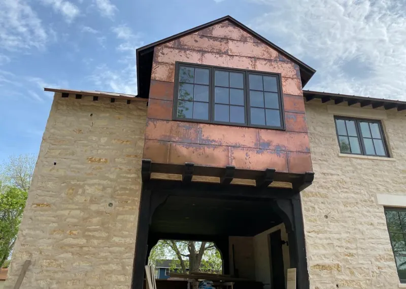 Copper metal panel facade on a stone building for Skylight Installation in McLendon-Chisholm