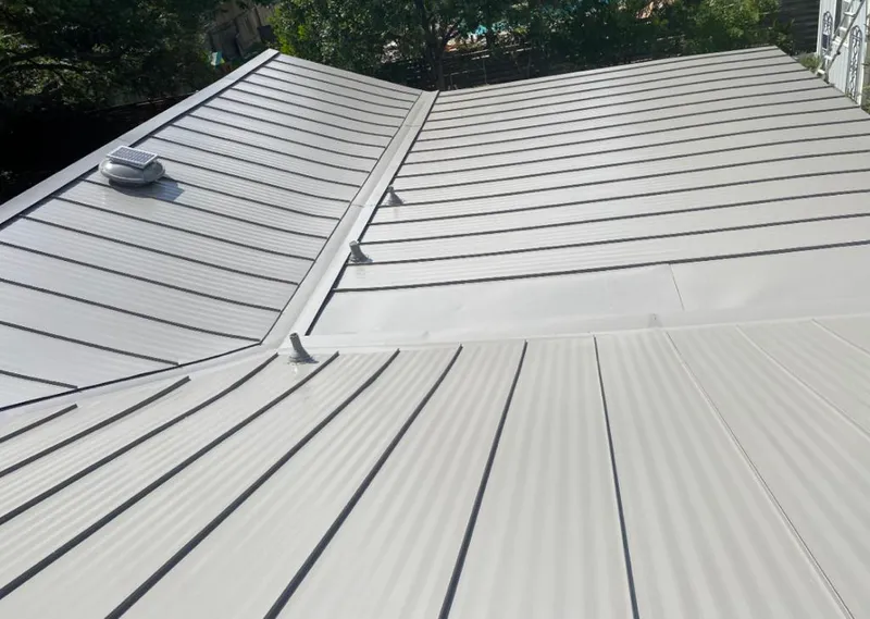 Solar attic fan installed on a metal roof for Roof Ventilation in McLendon-Chisholm